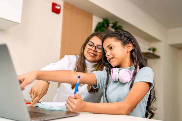 Mother and daughter doing schoolwork together on a laptop